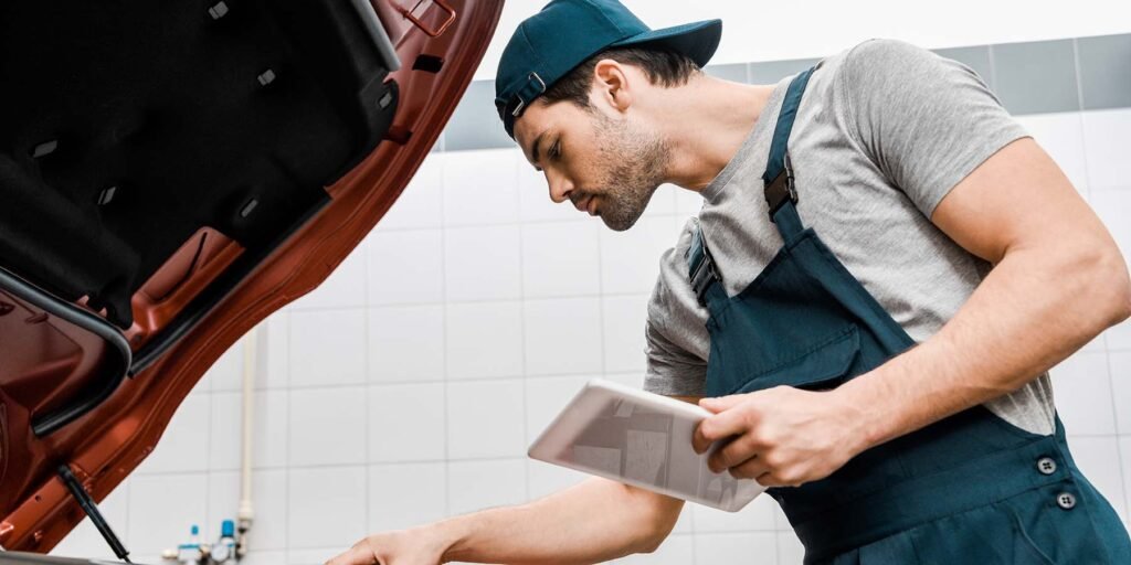 side-view-of-auto-mechanic-with-tablet-checking-ca-CJFYZUR.jpg